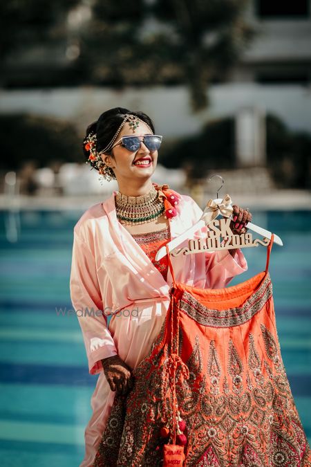 Photo of Bride holding lehenga on personalised hanger