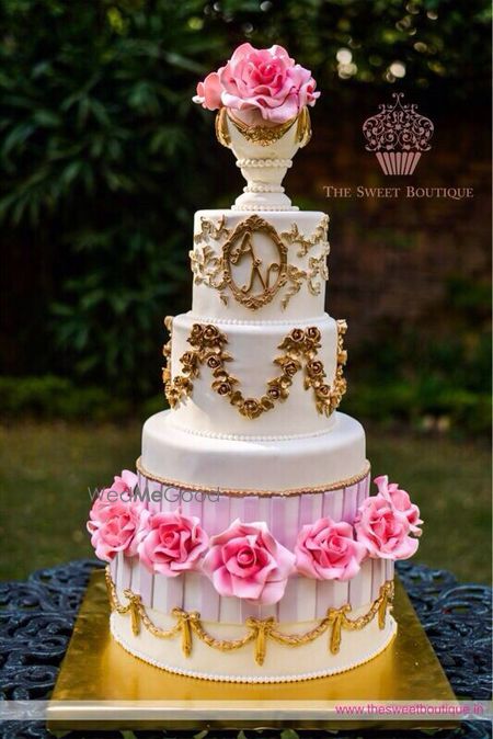 Photo of multi story white and gold wedding cake