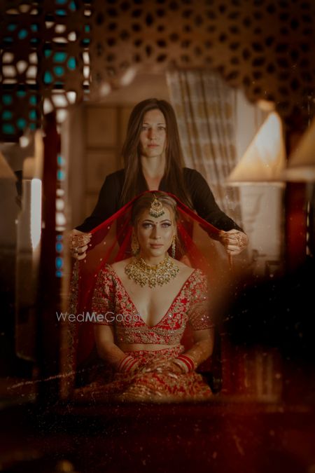 Photo of Bride in red with dupatta placing on head shot