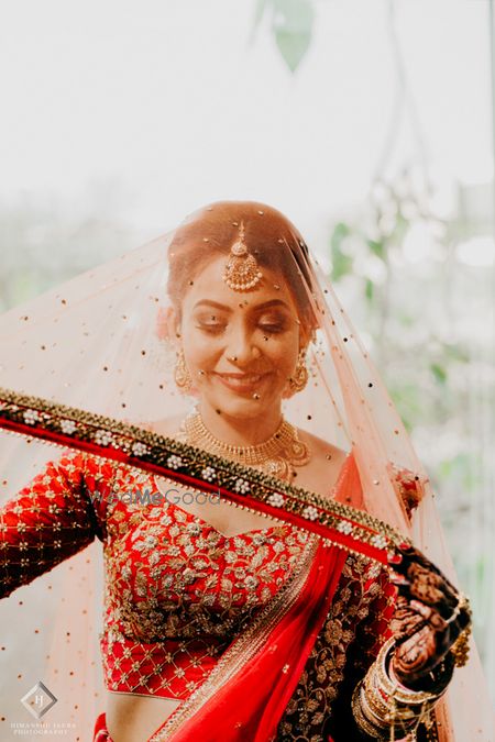 Photo of Bridal portrait holding her dupatta as veil