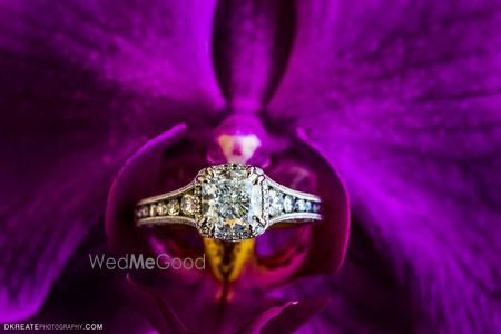 Photo of engagement ring on a purple flower