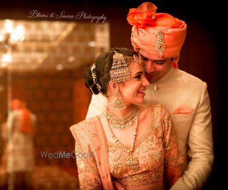 Photo of Bride and groom in coordinated peach outfits