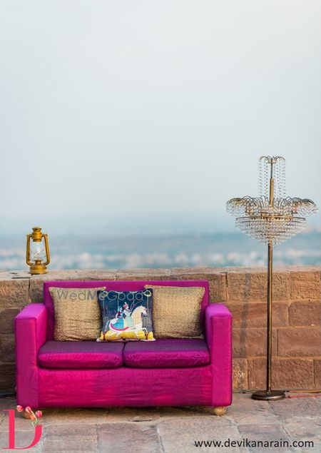 Photo of Hot Pink Sofa with Gold Cushions and Lantern Decor