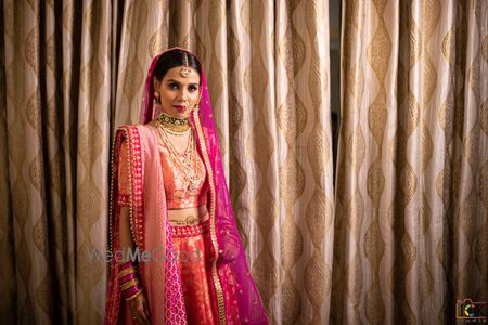 Photo of bride in orange and pink banarasi lehenga on her wedding