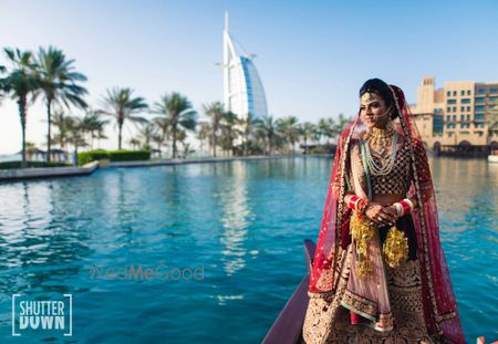 Photo of bridal portrait outdoors in maroon velvet lehenga