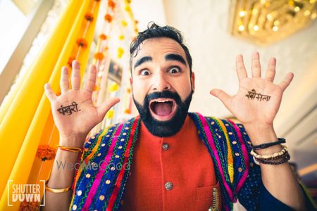 Photo of crazy groom showing off mehendi shot