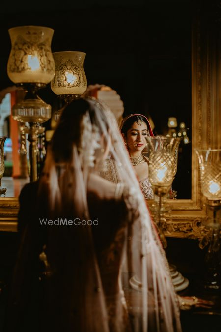 Photo of bride looking at herself in the mirror