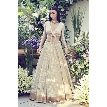 Photo of unique engagement lehenga in beige with tie up blouse