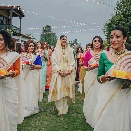 Photo of Bride entering with bridesmaids dressed in coordinated outfits