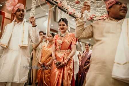 Photo of A South Indian bride making an entry under a phoolon ki chaadar.