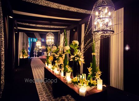 Photo of hanging birdcage with fairy lights and floral table centerpieces black and white theme cocktail