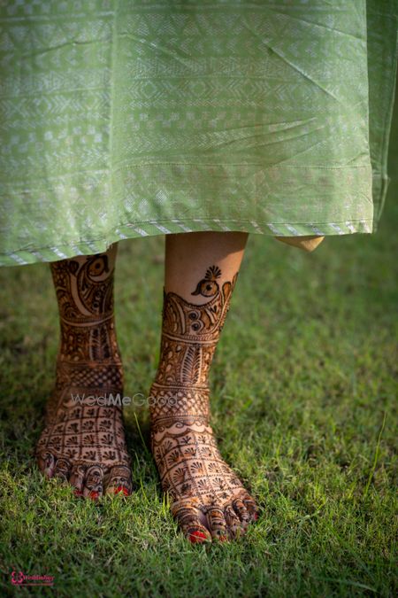 Photo of Feet Mehendi design with peacocks and jaalidaar patterns.