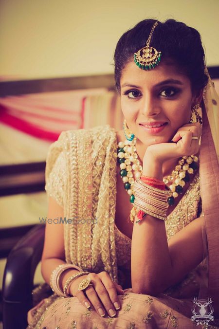 Photo of Bride in gold with green jewellery