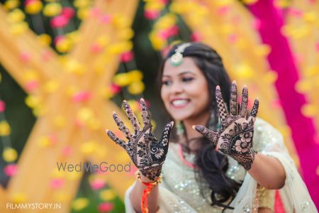 Photo of bride showing off her simple bridal mehendi