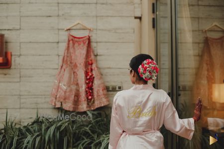 Photo of bride in robe posing with her lehenga