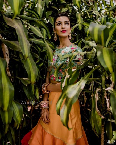 Photo of Bride wearing a printed crop top with a plain yellow skirt.