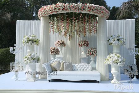 Photo of All white stage with floral decorations.