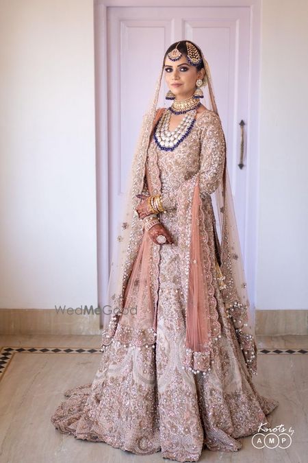 Photo of Bride dressed in an ivory and gold bridal outfit.