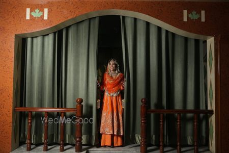 Photo of Bride in an orange suit with flared pants