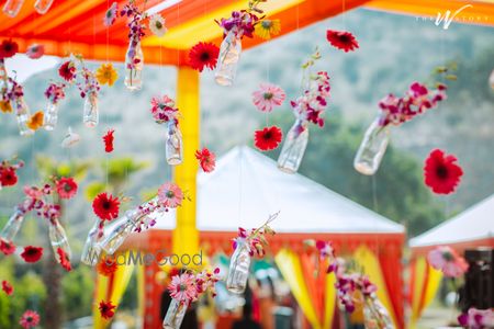 Photo of Diy backdrop with glass bottles filled with flowers.