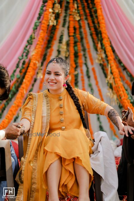 Photo of Bride wearing a simple yellow suit for mehendi